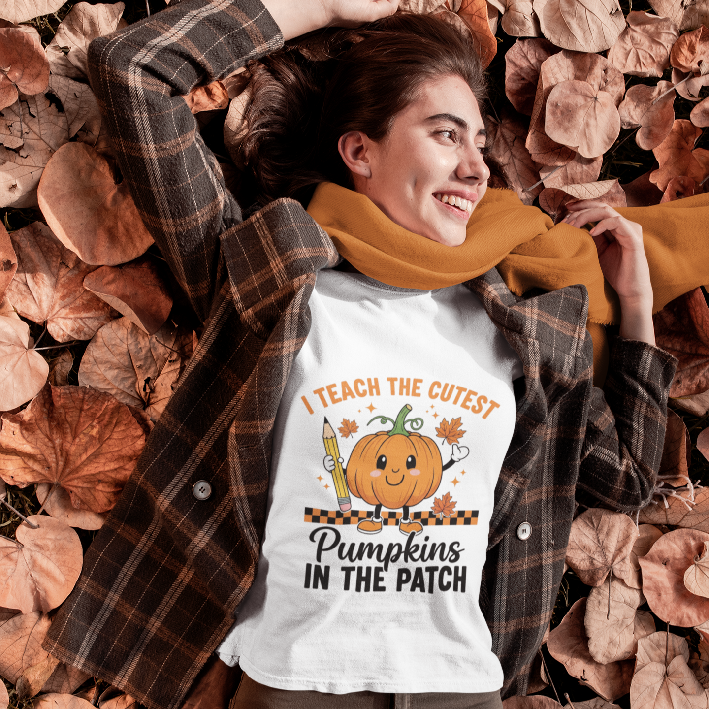 Woman wearing a white cute fall teacher tee that says “I Teach The Cutest Pumpkins In The Patch.