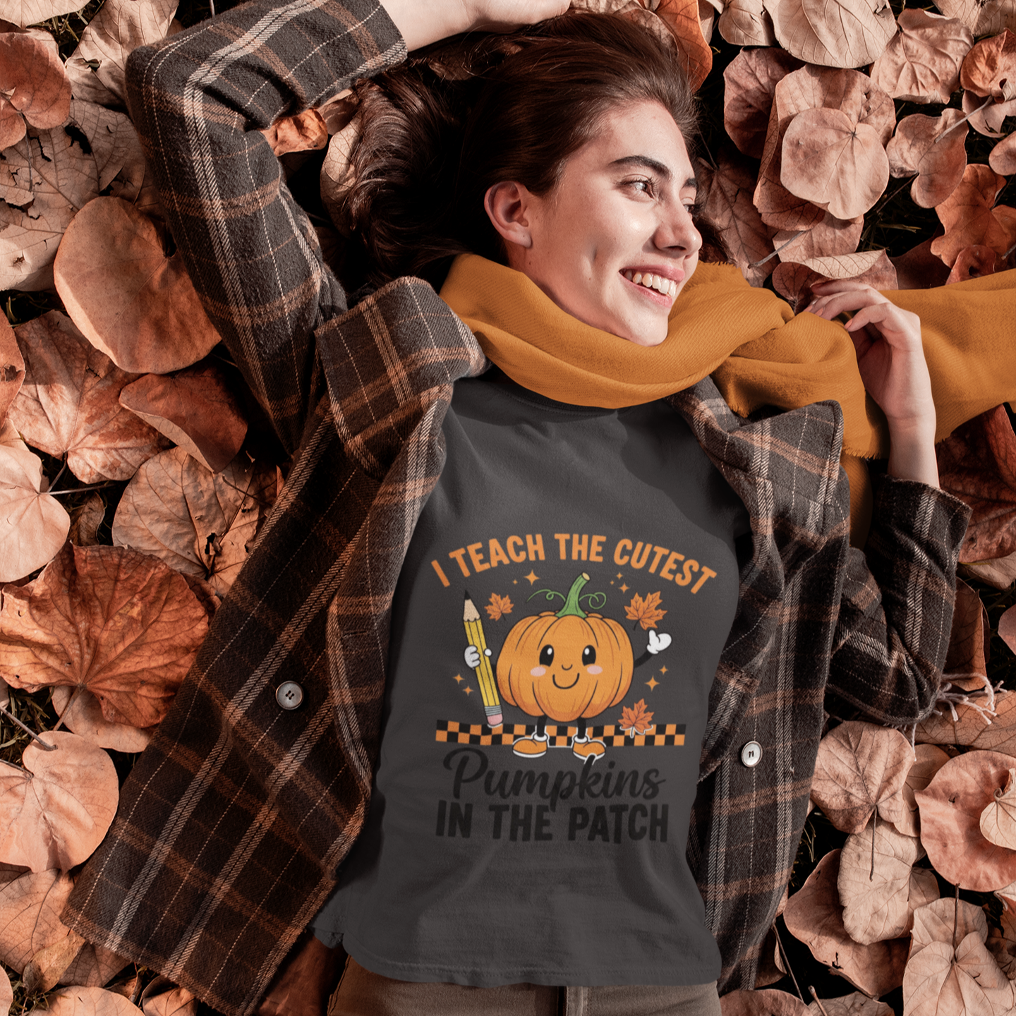 Woman wearing a black cute fall teacher tee that says “I Teach The Cutest Pumpkins In The Patch.