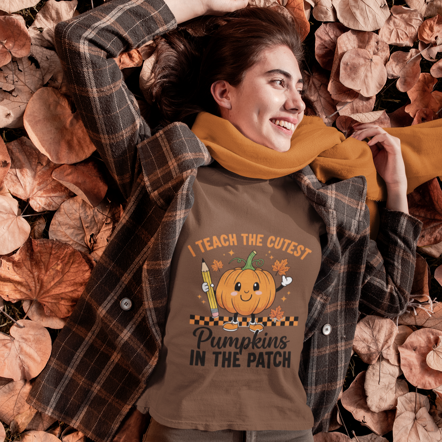 Woman wearing a brown cute fall teacher tee that says “I Teach The Cutest Pumpkins In The Patch.