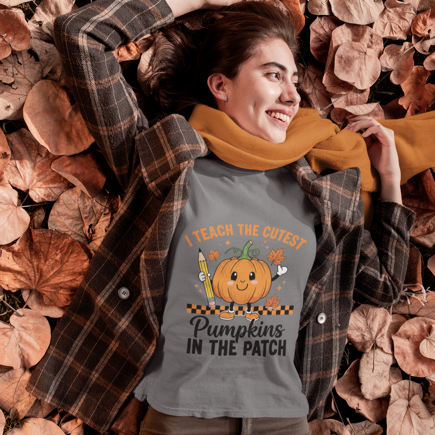Woman wearing a gray cute fall teacher tee that says “I Teach The Cutest Pumpkins In The Patch.